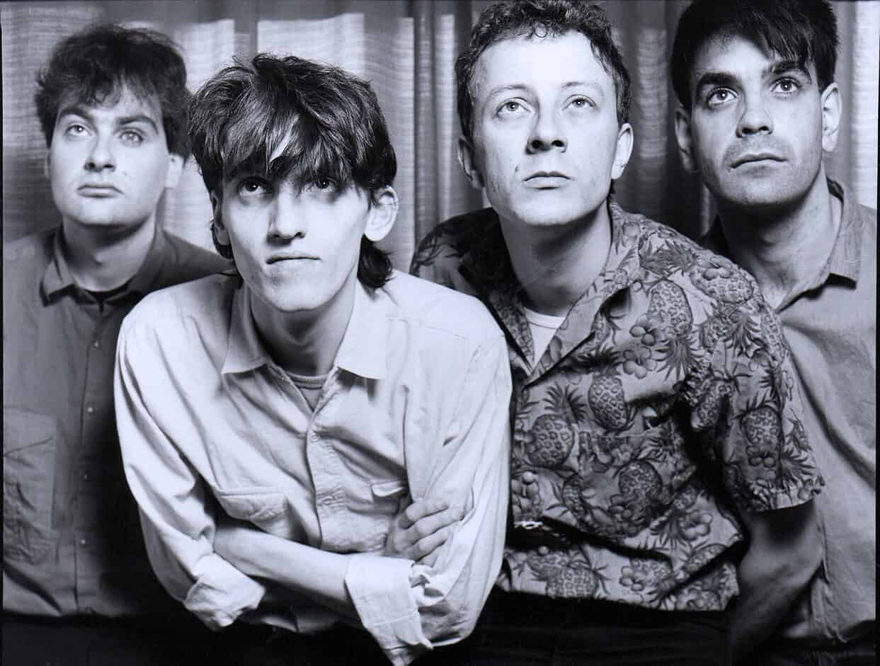 People in a black and white photo of the band Nirvana, showcasing the band members, Kurt Cobain, Krist Novoselic, and Dave Grohl, highlighting iconic musical history and alternative rock music.