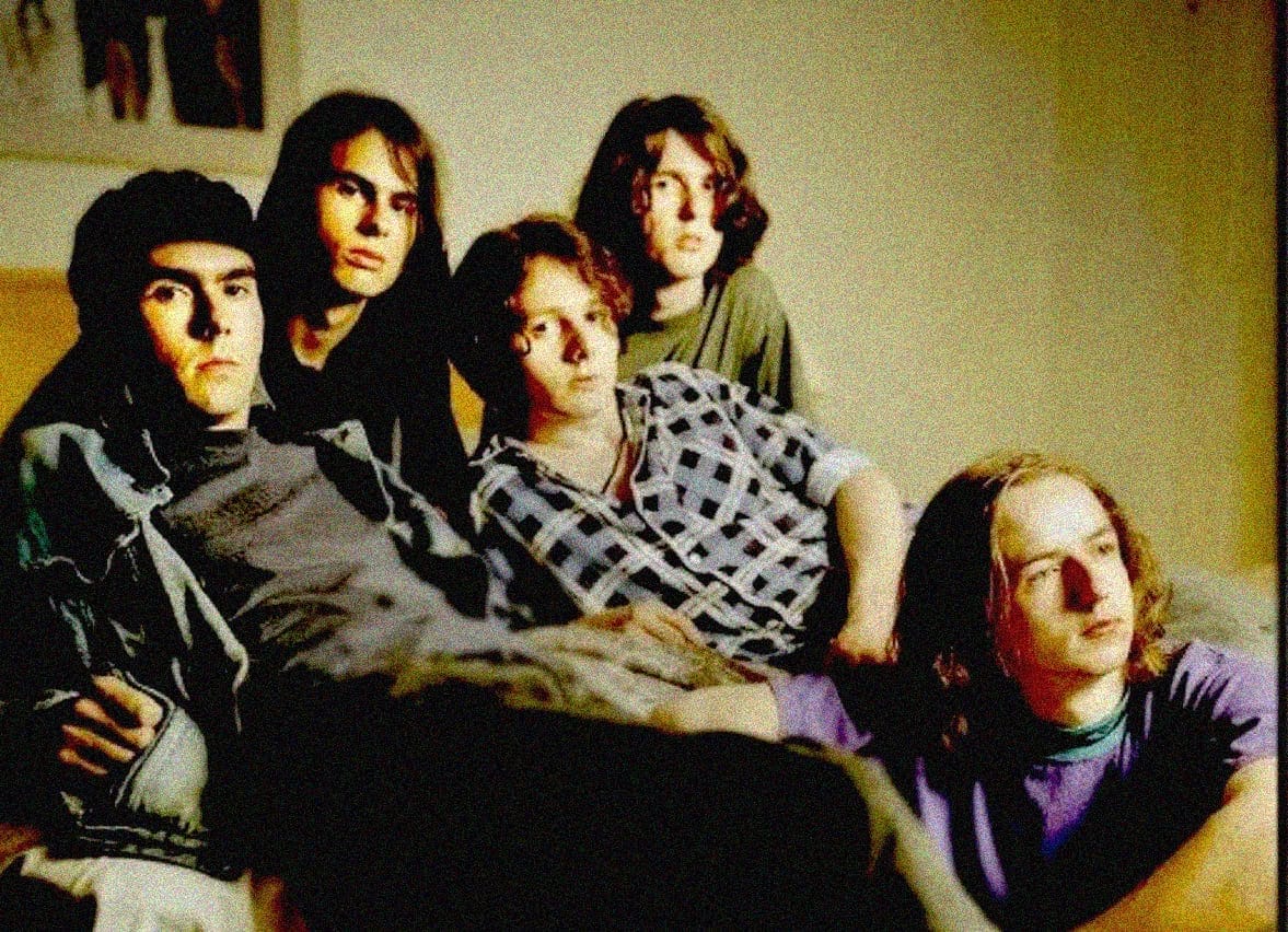 Band of young adults sitting together in a casual indoor setting, representing music, history, and cultural archives for Past Daily sound archive collection.