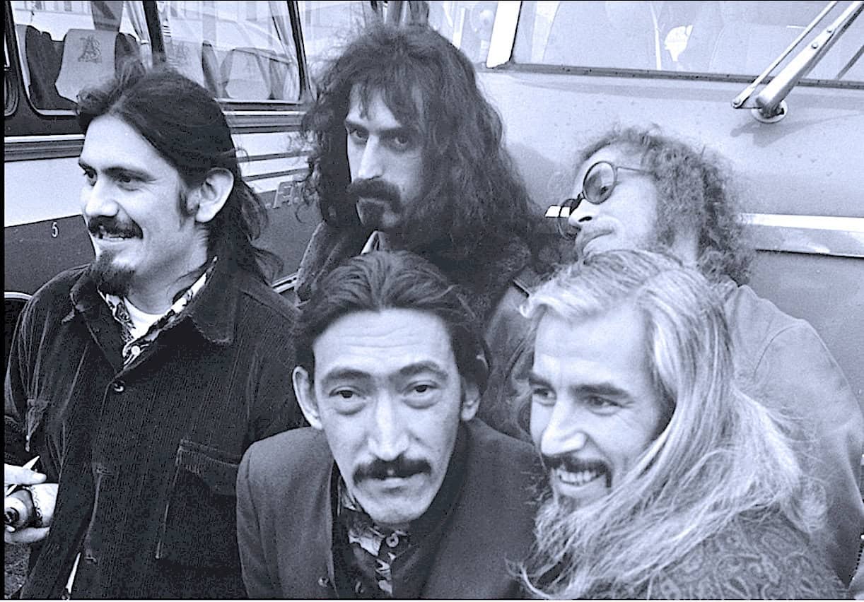 Boarding a bus with vintage rock band members, black and white photo, iconic music scene, nostalgic music history, classic band members, music archive, past daily, sound archive of news and music.