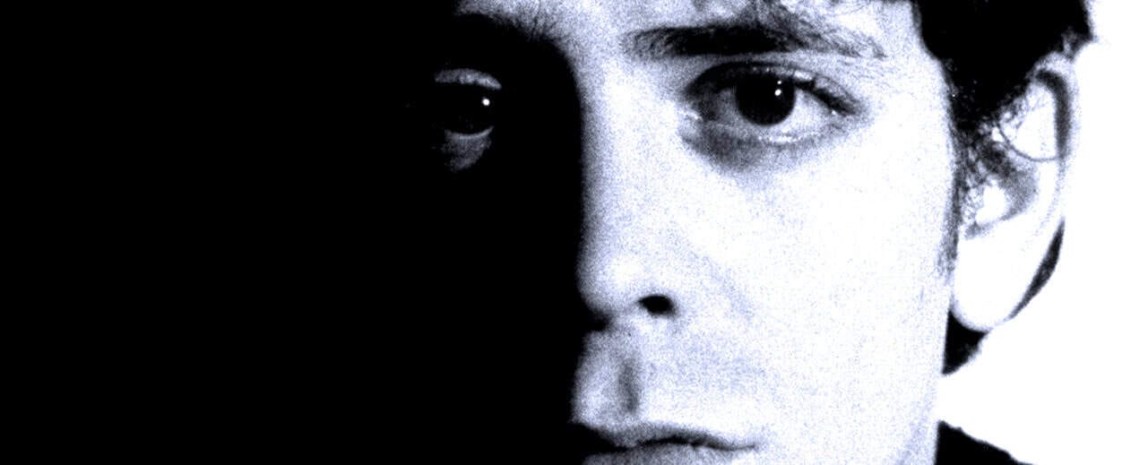 Close-up of a young person's face with half-shaded lighting, emphasizing dramatic contrast to evoke themes of music, history, and news archival content.