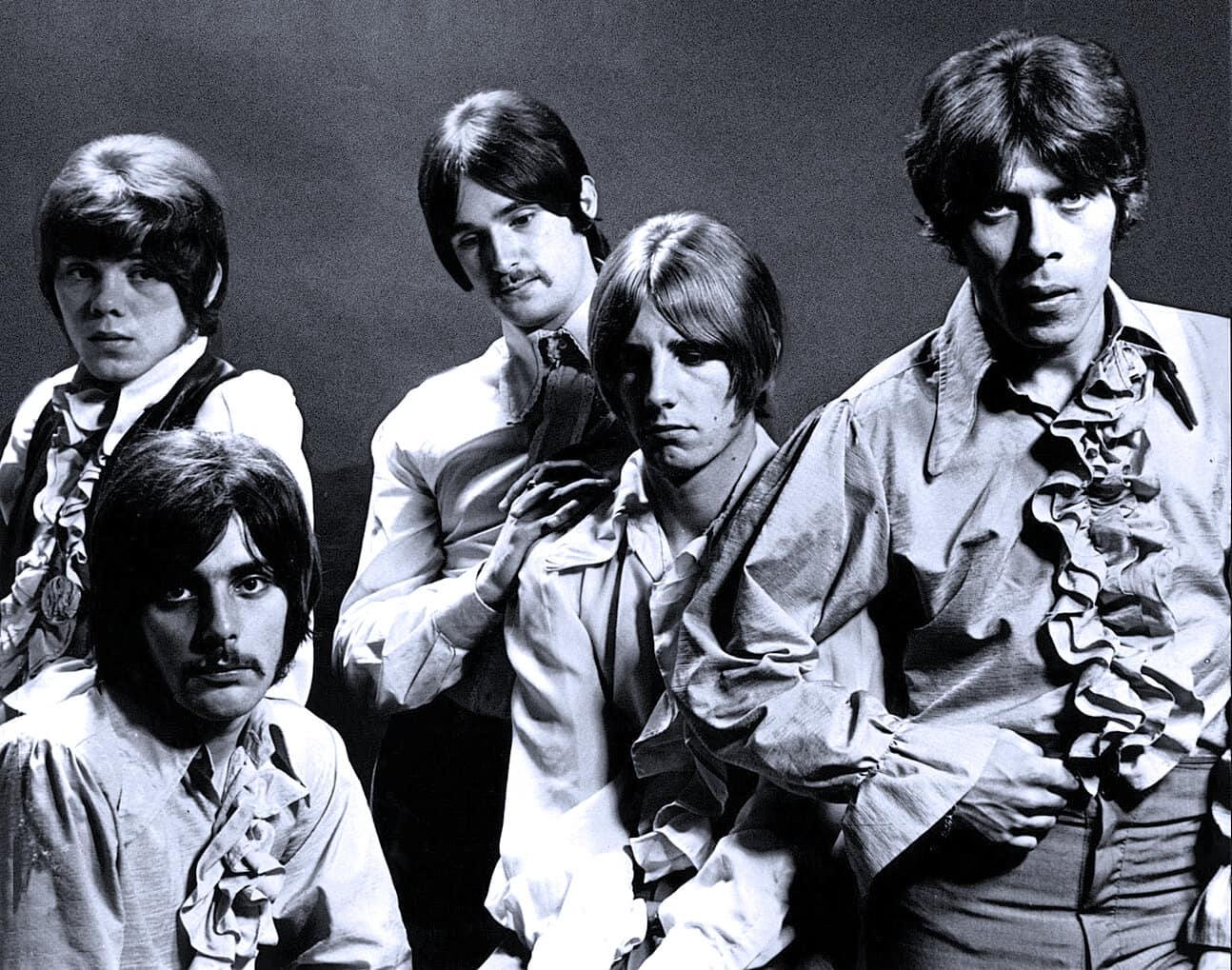 1960s British band The Beatles in a black and white promotional photo, showcasing their iconic style and influence on music history, available on Past Daily archive for news, history, and music lovers.