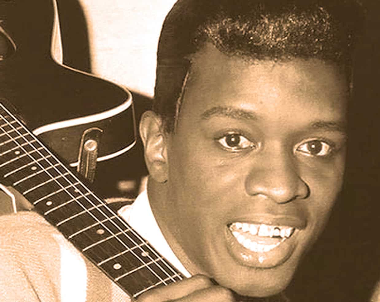 A young person holding an acoustic guitar, smiling, in a nostalgic sepia tone image emphasizing music, history, and cultural heritage.
