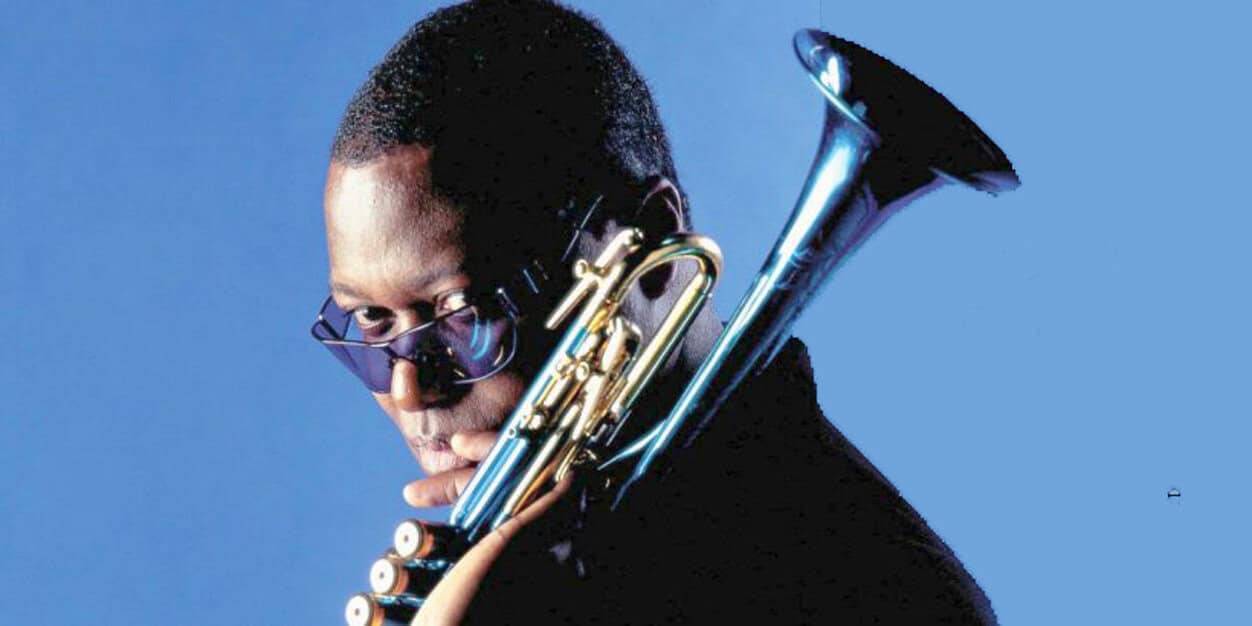 Jazzy saxophonist wearing sunglasses, playing a silver saxophone against a solid blue background, representing music, jazz, and historic sound recordings.