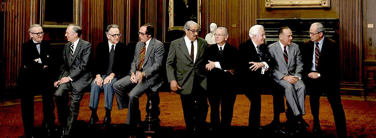 Former US presidents sitting on a bench in a historic wooden-paneled room during a meeting or discussion about American history and politics.