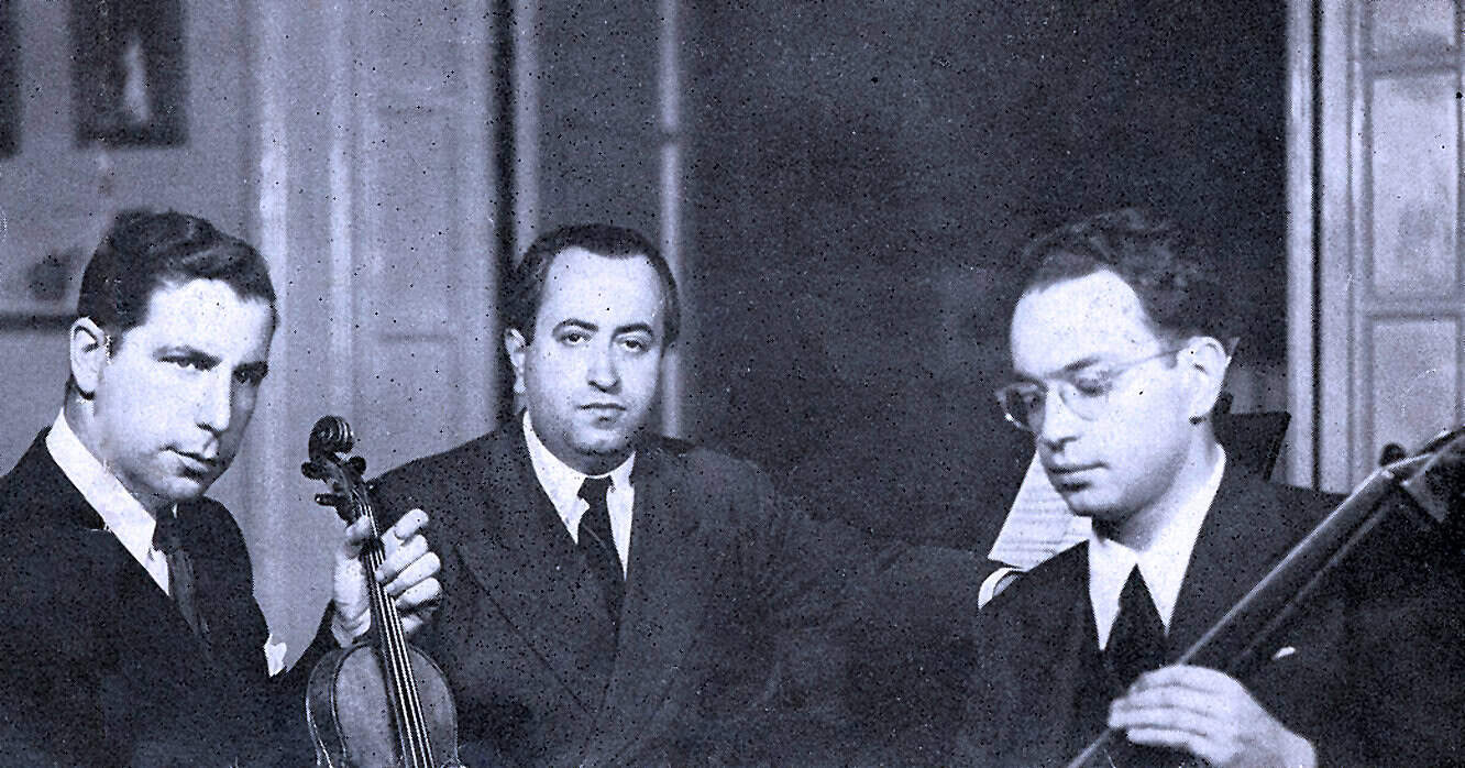 Vintage black and white photo of three musicians playing classical instruments in a historic setting, showcasing the rich cultural heritage and musical history archived at Past Daily.