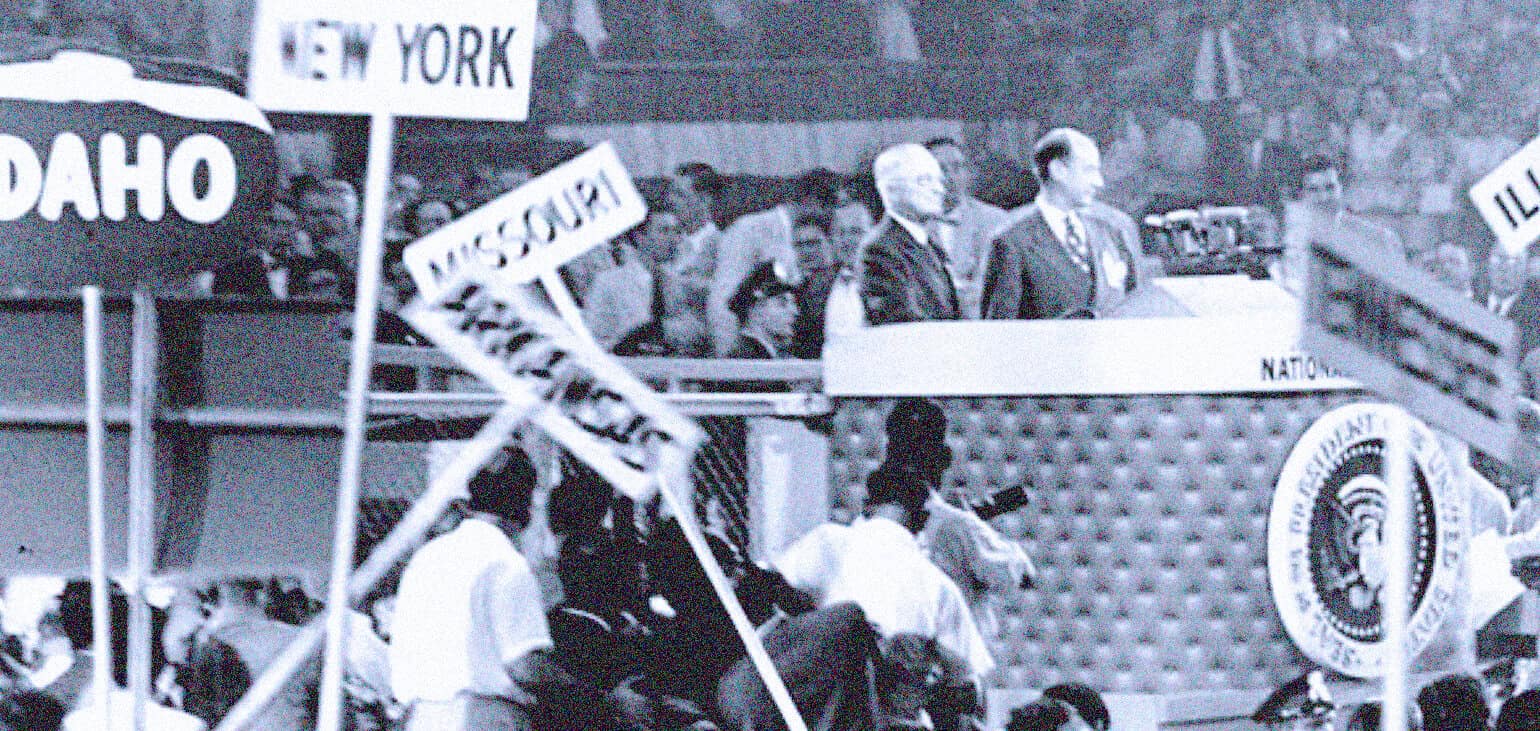 Historic black and white photo of a civil rights protest with signs for states like New York, Idaho, Missouri, and Illinois, featuring political leaders and civil rights activists at a rally.