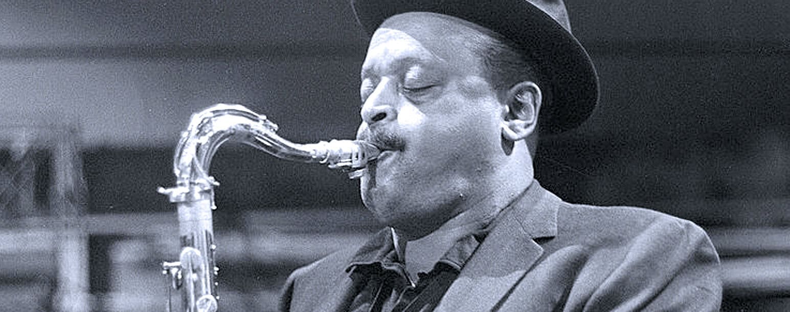 Vintage jazz musician playing saxophone in black and white, capturing iconic music history scene.