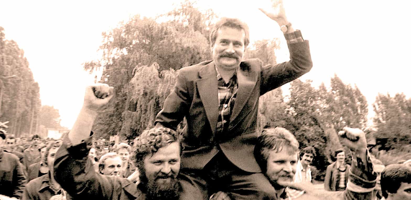 Historic protest rally with a man raising fist, crowd of supporters, outdoor setting, activism, social movement, vintage black-and-white photo, capturing news, history, and political advocacy.