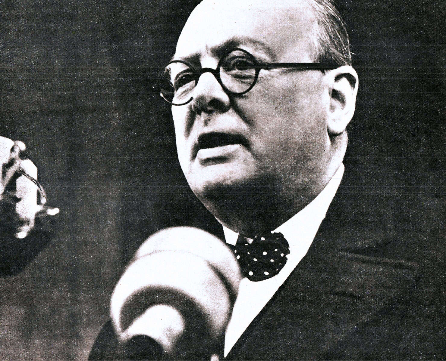 Portrait of a distinguished man speaking into a microphone, emphasizing historical news and media coverage, ideal for content related to past news archives, historical speeches, and classic journalism.