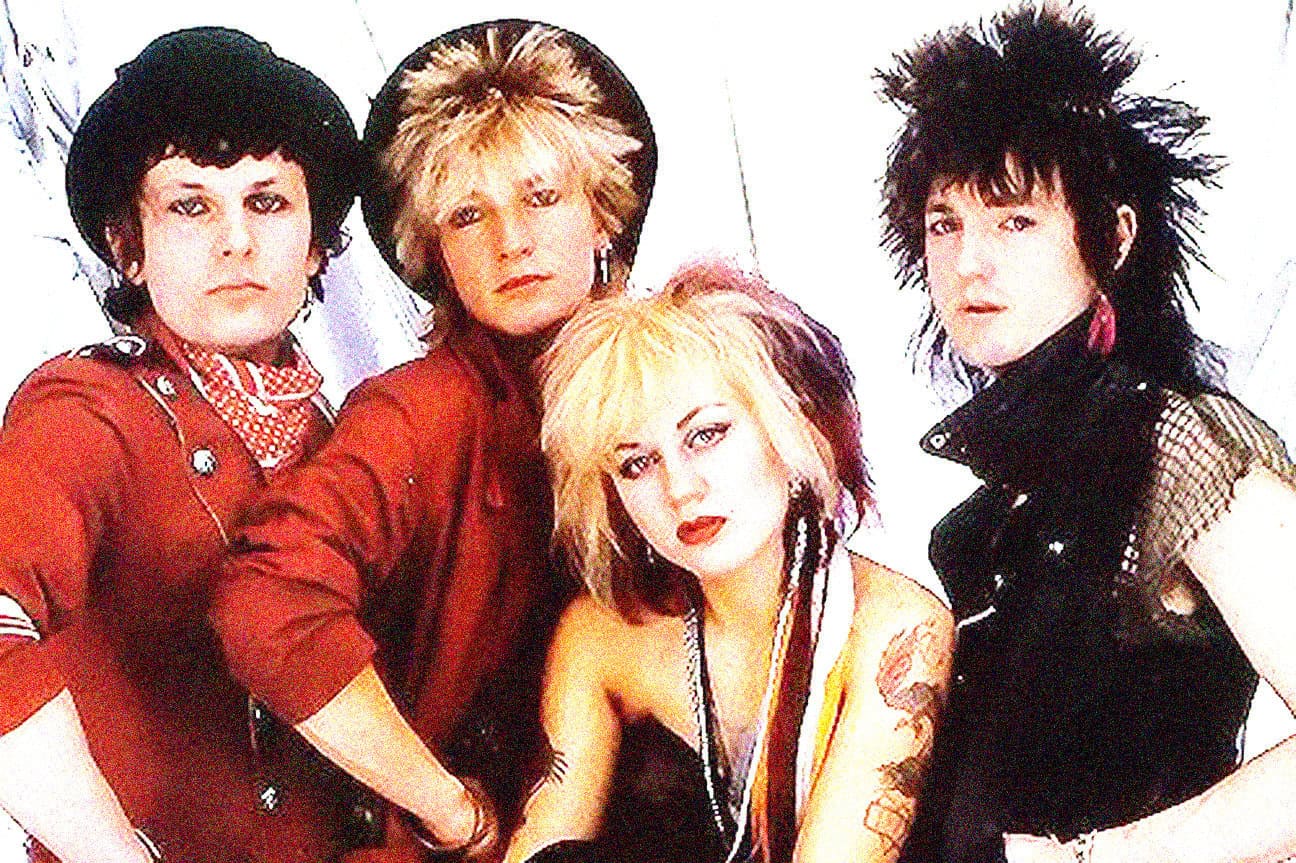 Rock band with punk and alternative style, four members, vibrant fashion, distinctive hairstyles, energetic pose, music history, 1980s music scene, edgy attitude, alternative music group, band photo professional shot.