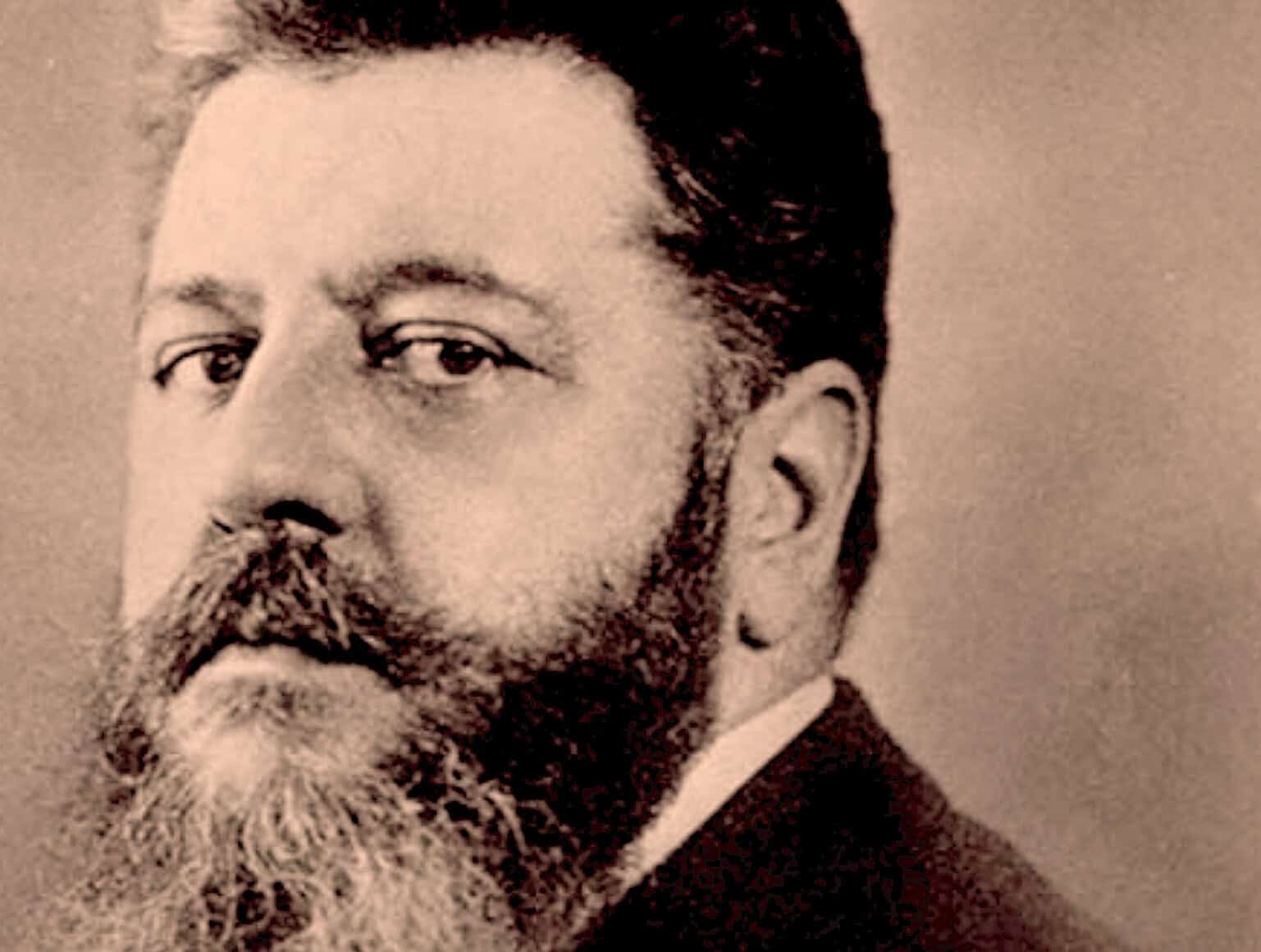 Vintage black and white photograph of a distinguished man with a beard, representing historical news, music, and radio archives.