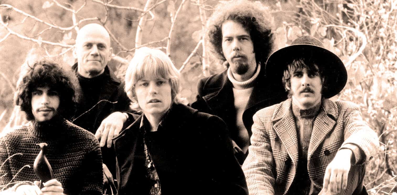 Vintage black and white photo of The Doors band outdoors, showcasing legendary rock musicians Jim Morrison, Ray Manzarek, Robby Krieger, and John Densmore, celebrated in music history archives.