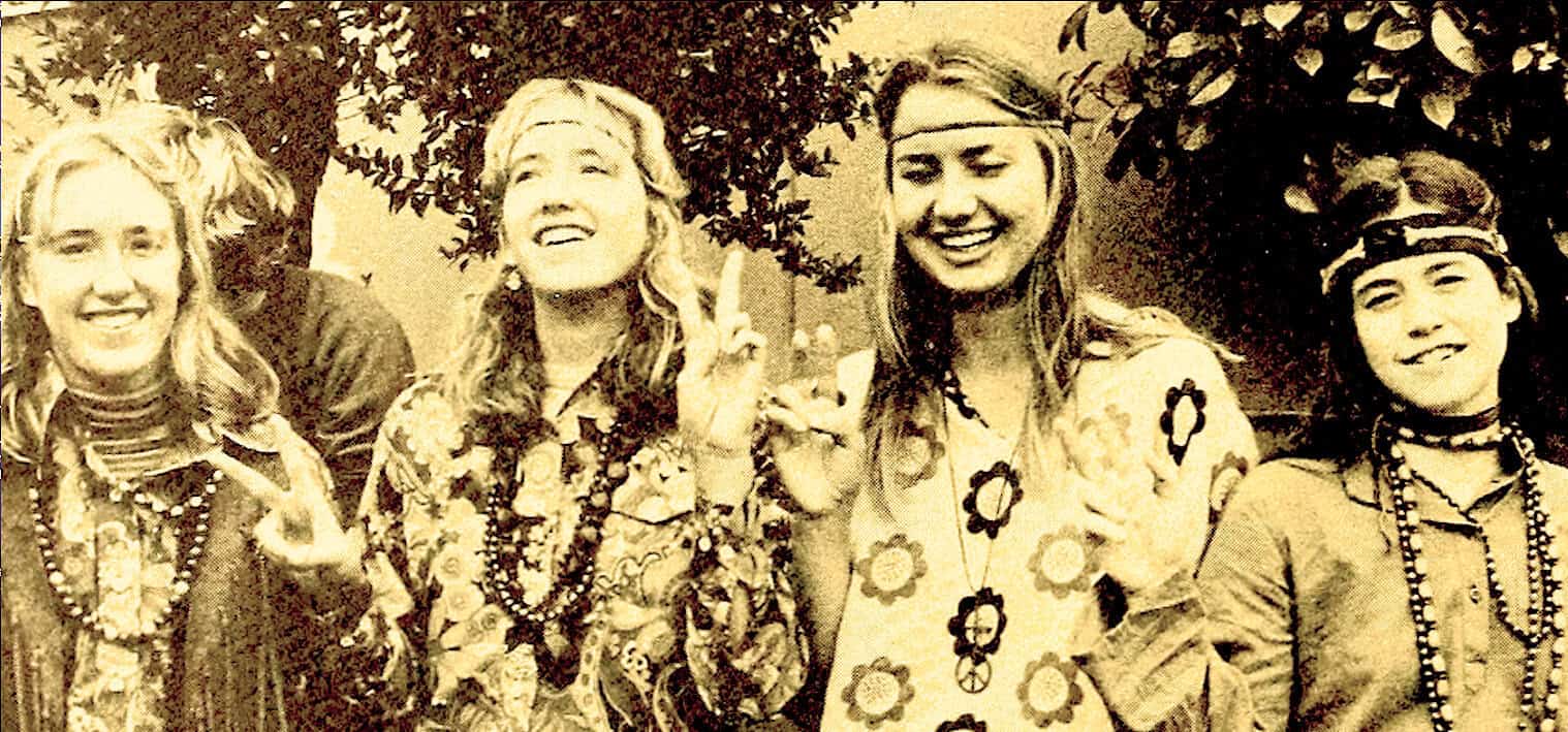 Women celebrating 1960s peace and love movement at Woodstock festival, vintage black and white photo, peace sign, folk music and counterculture scene.