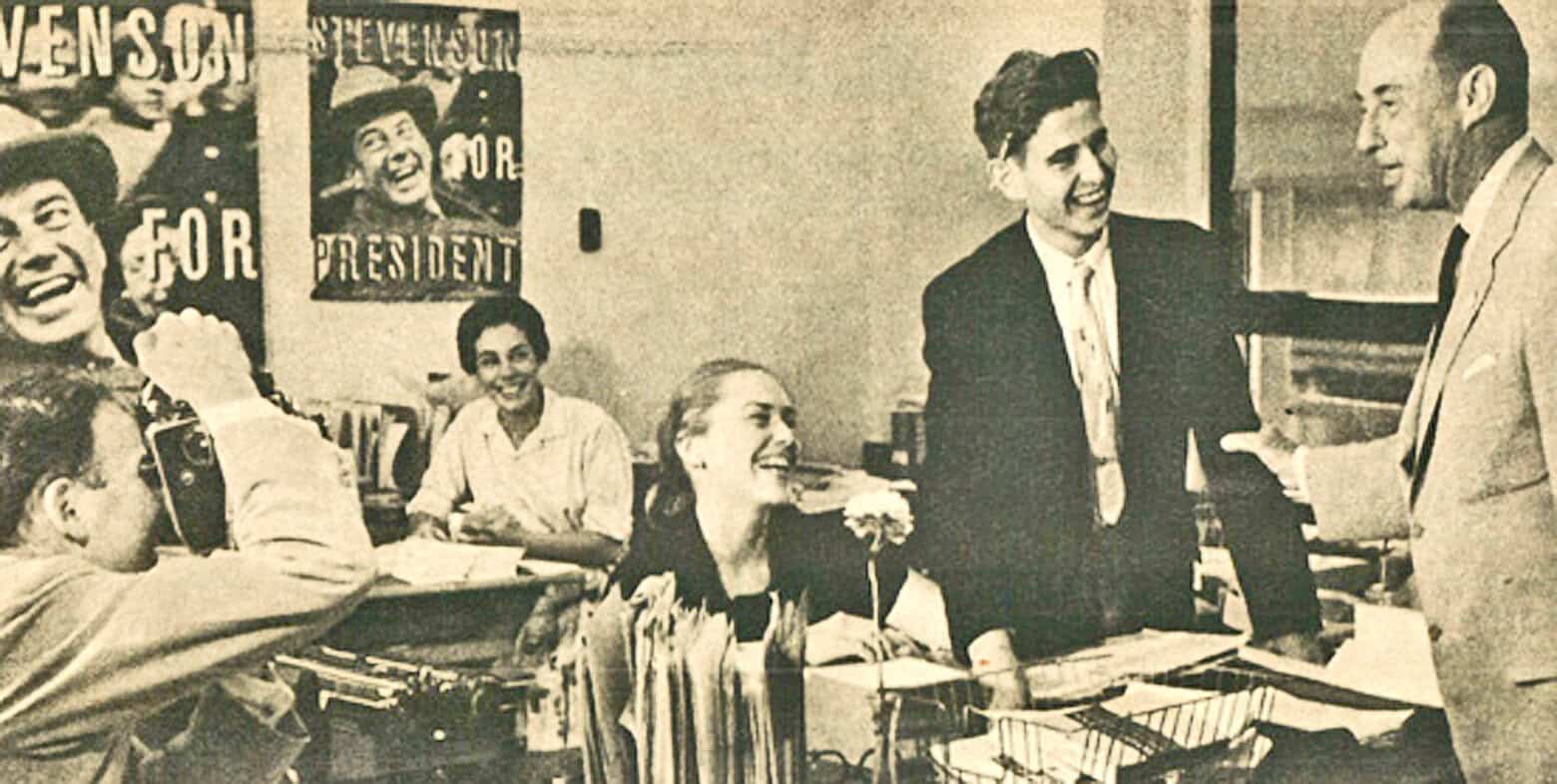 Vintage black and white photo of a lively political campaign event with smiling candidates and supporters, highlighting historic election moments, news broadcasting, and media coverage in American political history.