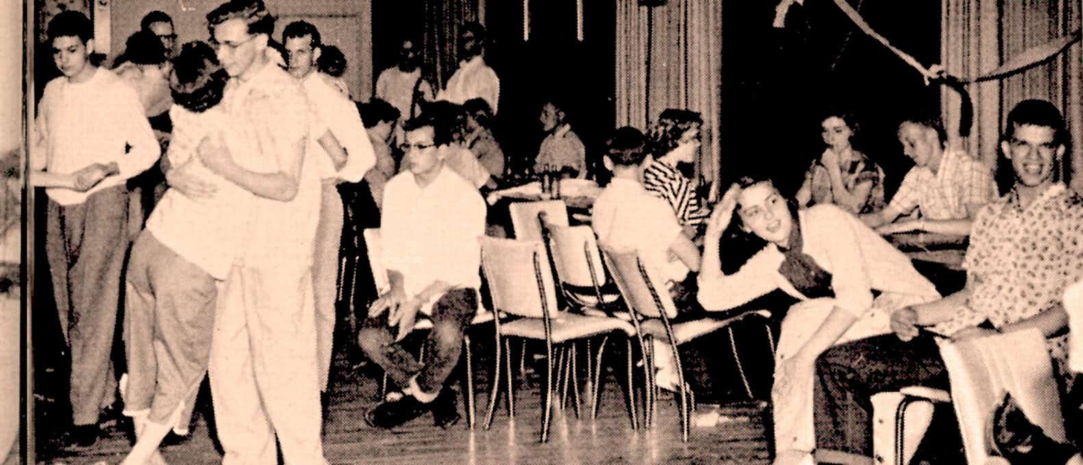 1950s schoolchildren gathering and studying in classroom, vintage black and white photo, historical education scene, nostalgic learning environment, educational history.
