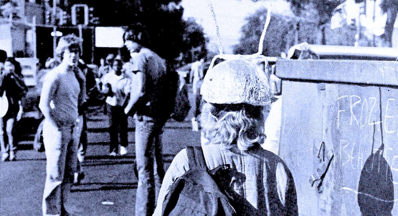 Displaced persons waiting in line at a refugee camp, with makeshift tents and signs, highlight humanitarian crisis; historical photo emphasizing resilience, migration, and aid efforts.