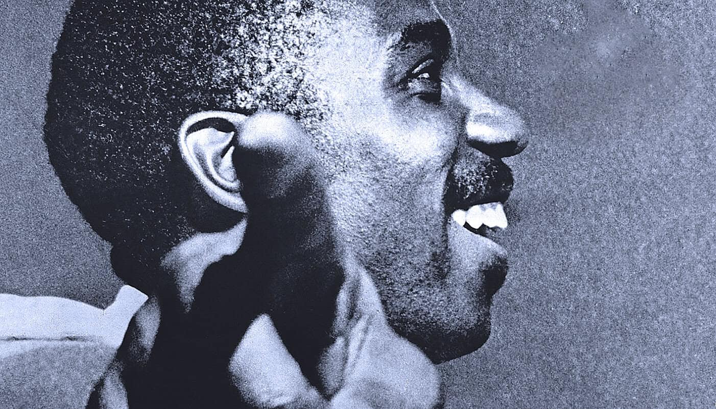 Black and white close-up of a joyful woman singing or speaking, highlighting emotions, music, history, and sound archive themes.