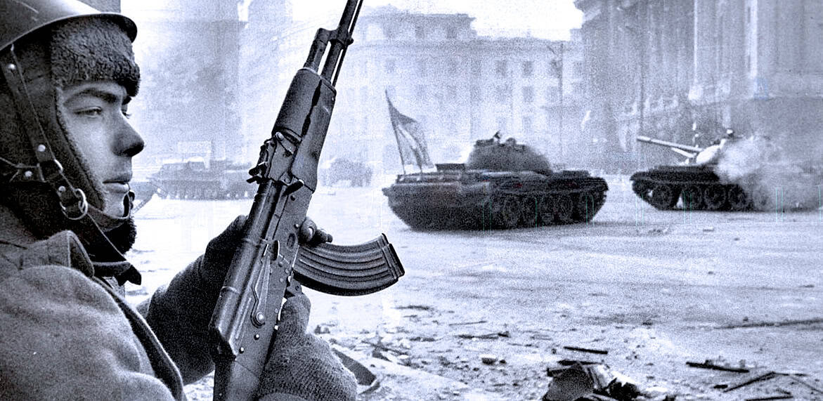 Military soldier holding assault rifle during battlefield scene with tanks in background, depicting wartime conflict and military history.