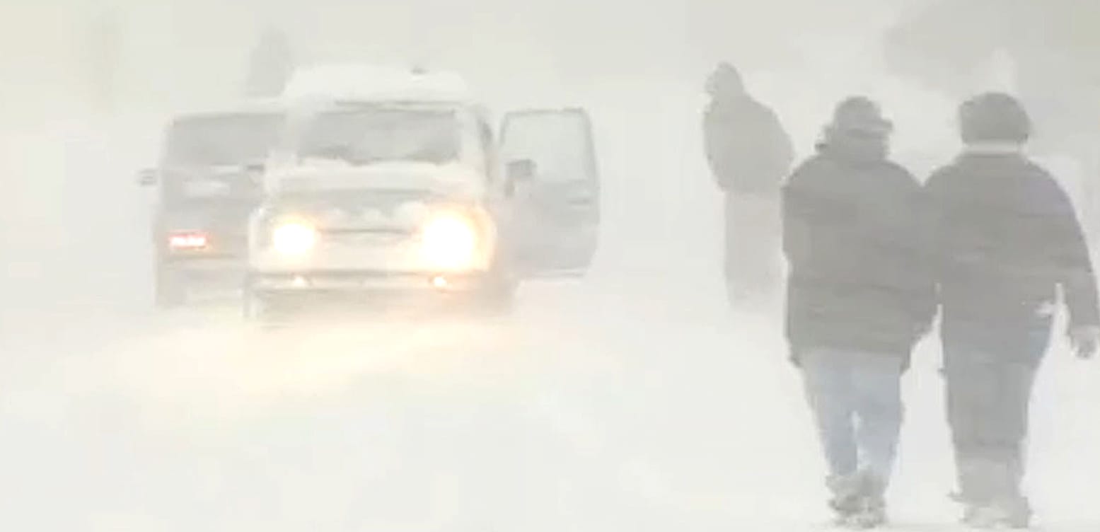 Blizzard snowstorm with pedestrians walking through heavy snow, cars struggling in winter weather, emphasizing the importance of weather news and historical snowfall records.