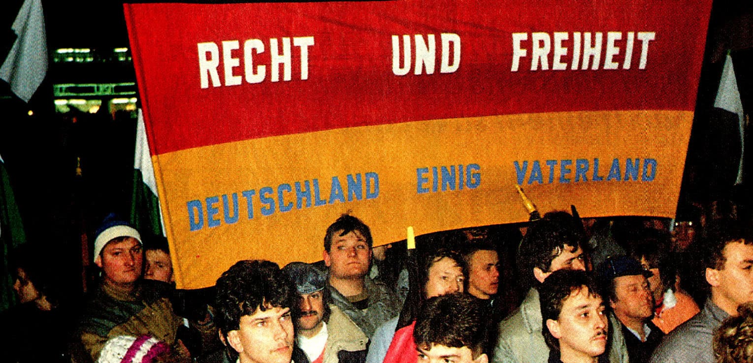 Revolutionary protest in Berlin with a large banner reading "Recht und Freiheit Deutschland einig Vaterland" highlighting German unity, freedom, and political activism.