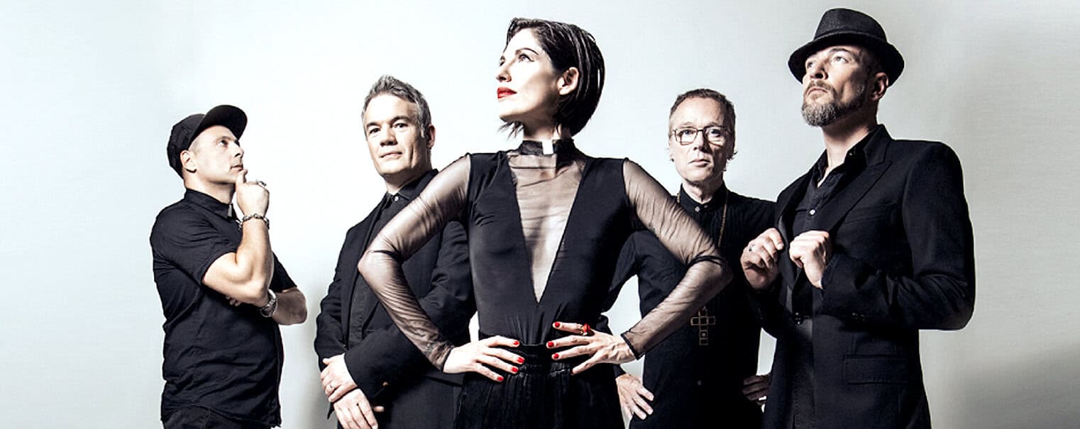 A diverse musical group posing confidently in stylish black outfits, emphasizing their connection to music, news, and history for an immersive audio archive experience.