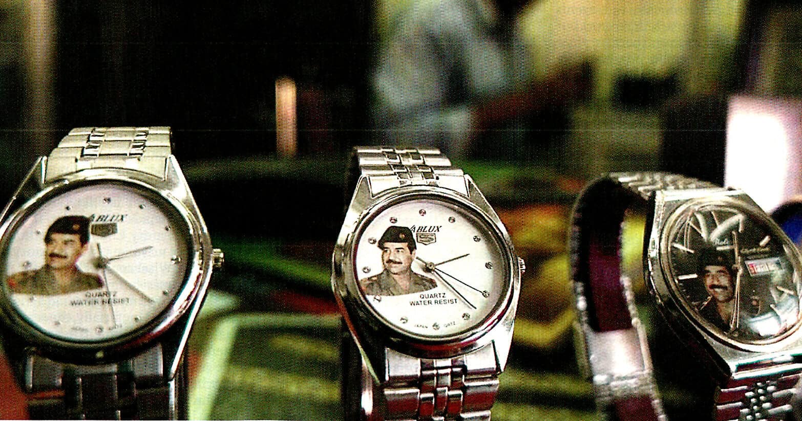 Watches featuring a retro image of Freddie Mercury from Queen on the dial, displayed on a reflective surface with a blurred background, emphasizing vintage style and music memorabilia.