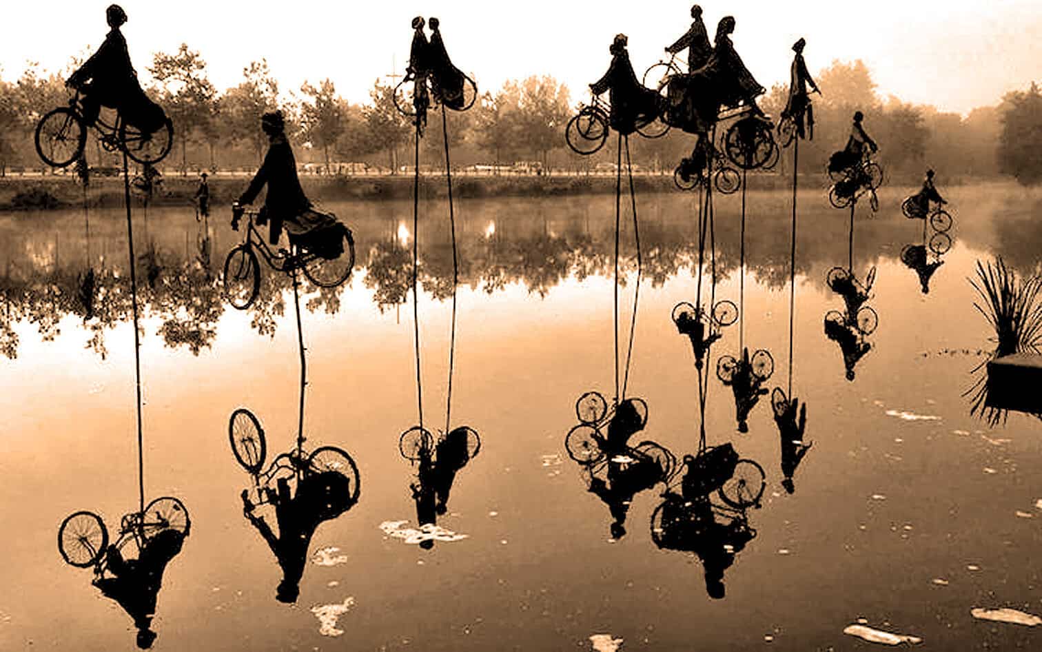 Silent row of people riding bicycles on stilts reflected in a calm lake during sunset, showcasing artistic photography and creative transportation.