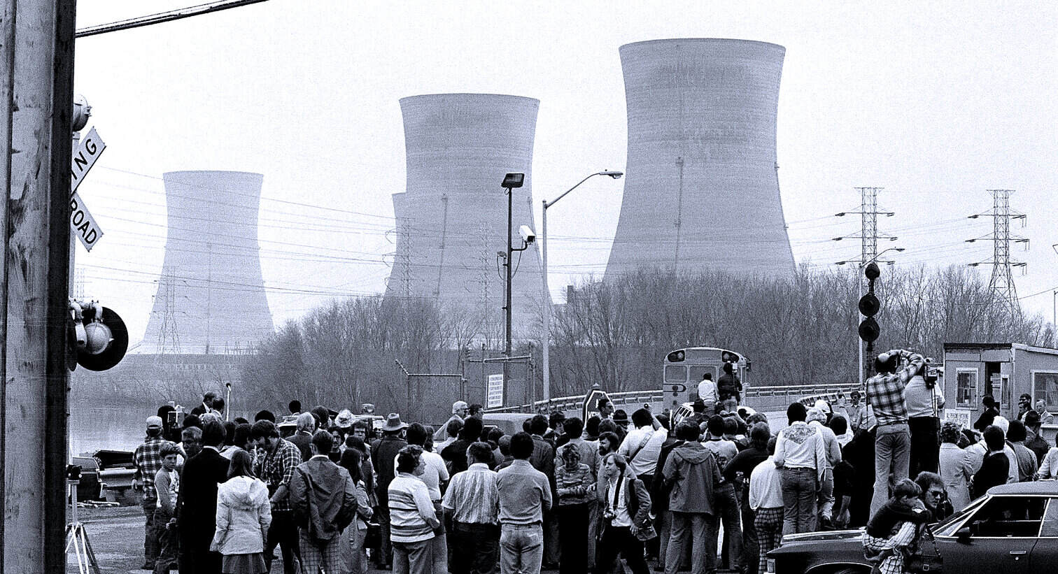 Nuclear power plant cooling towers with a crowd of people at the site, capturing industrial history and environmental impact.