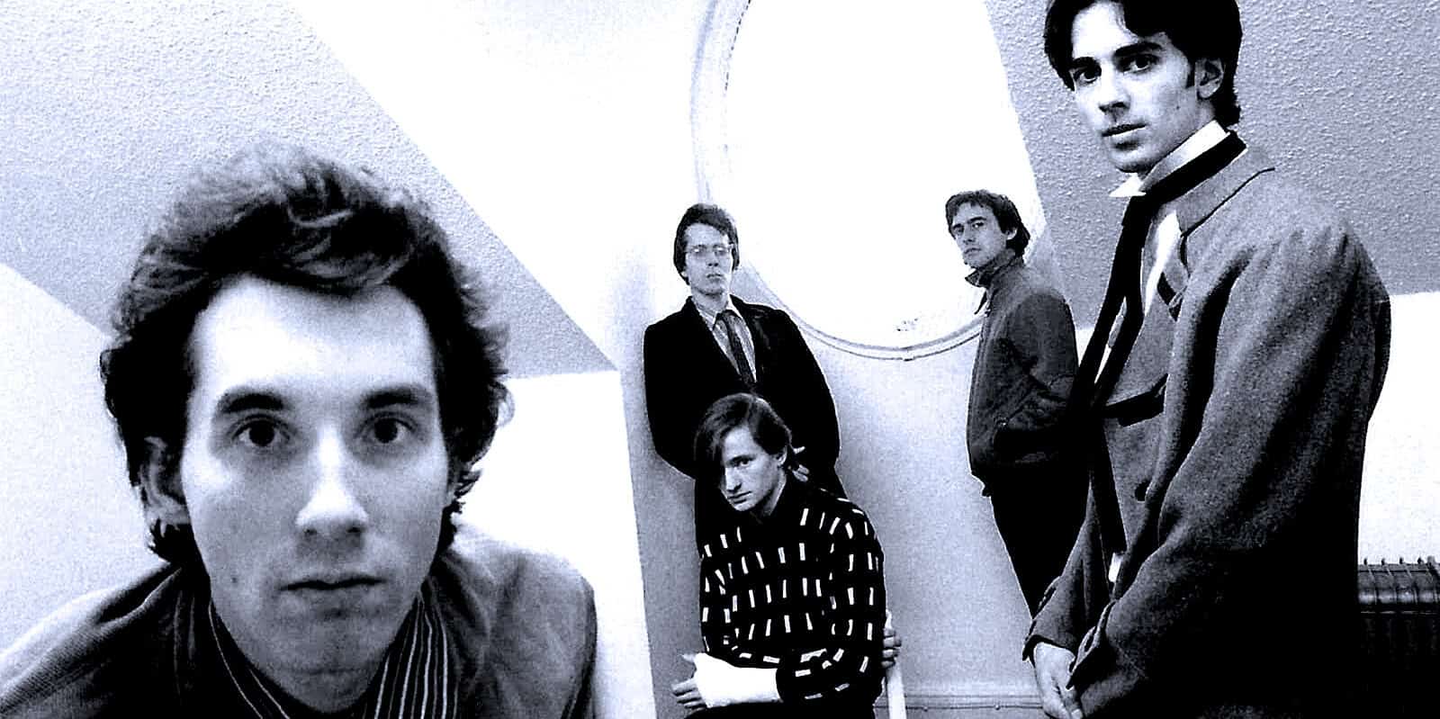 Black and white photo of The Smiths band members, featuring Morrissey, Johnny Marr, Andy Rourke, and Mike Joyce, capturing their 1980s indie rock style and iconic presence.