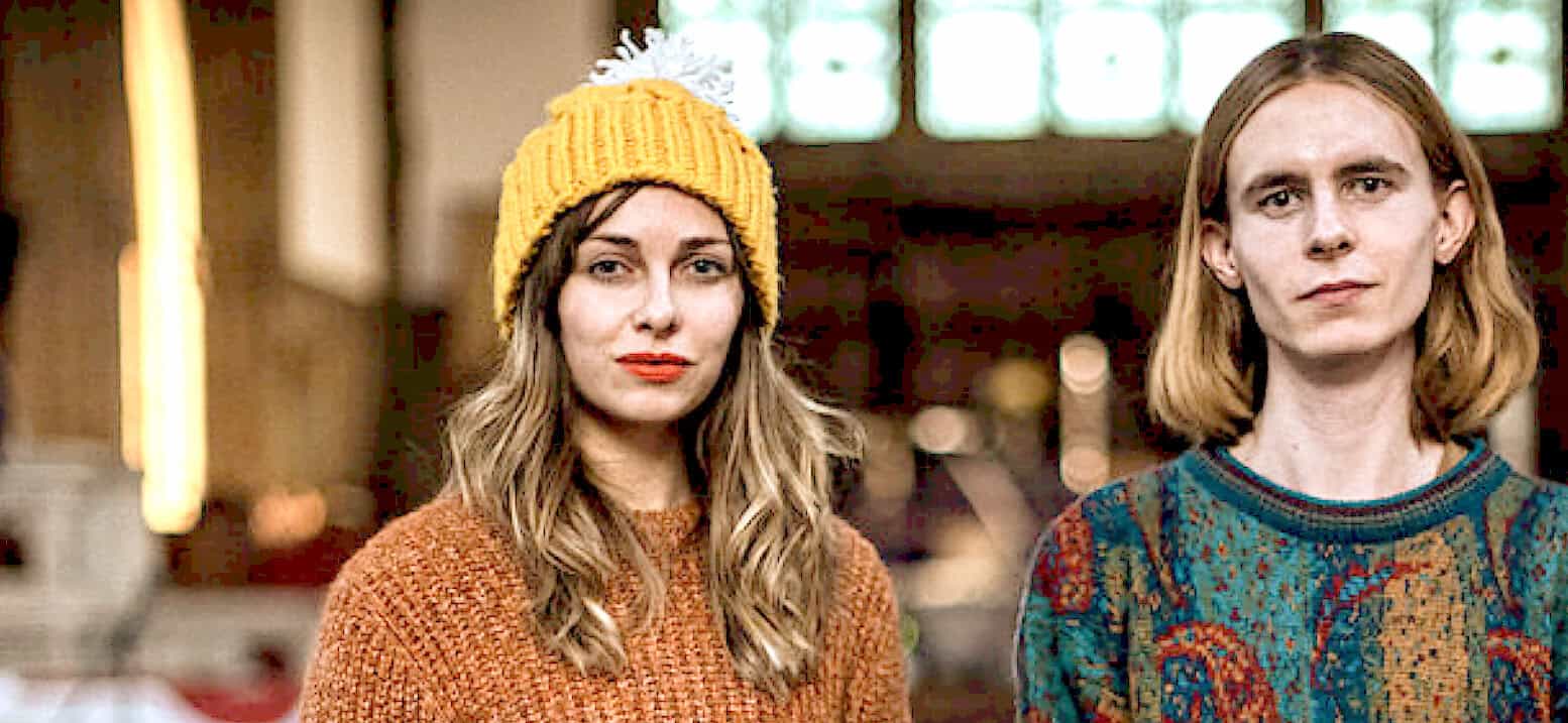 Portrait of a young woman and man with vintage style clothing in an indoor setting, emphasizing music, news, and cultural history.