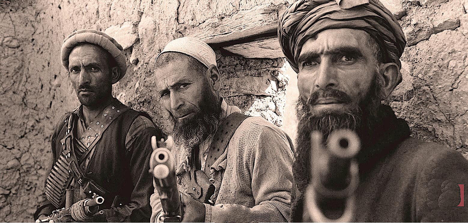 Armed men with guns in desert setting, historical photo, rugged terrain, Middle Eastern combat scene, vintage military imagery, soldiers with firearms, past daily archives, historical conflict photography, black and white military image.