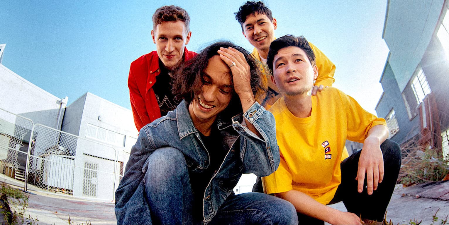 Vibrant group of diverse young friends outdoors on sunny day, casual streetwear, smiling and enjoying each other's company, representing friendship, youth culture, and urban lifestyle.