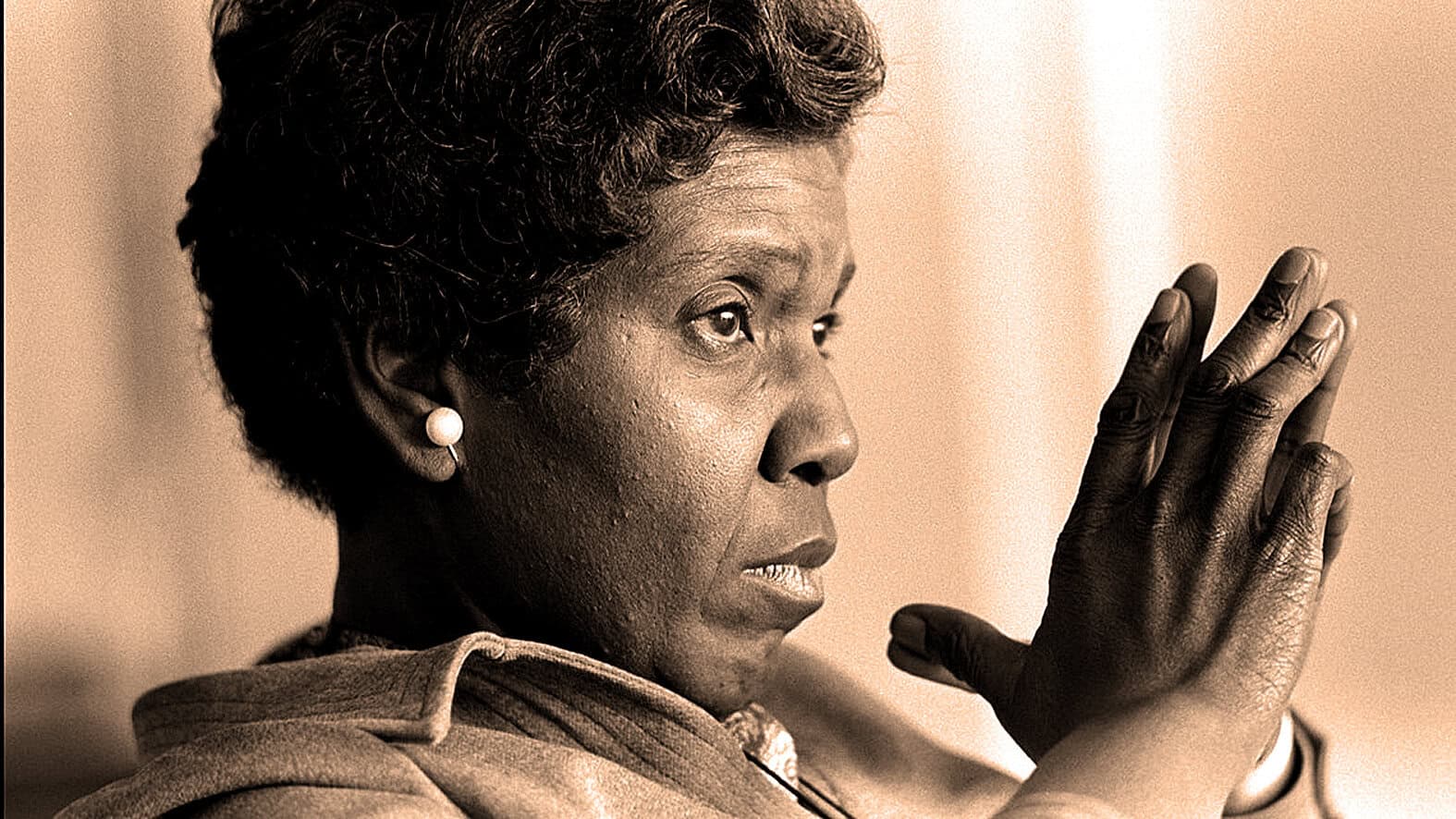 African American woman in profile with hands clasped in prayer, historical black and white photo, representing resilience, faith, and civil rights activism.
