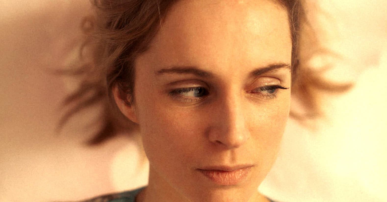 Evocative woman with styled hair, close-up portrait emphasizing her contemplative expression, representing the historical and music sound archive themes of Past Daily.