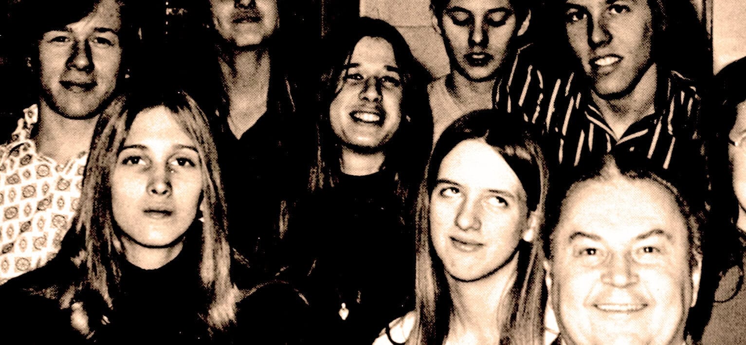 People in a vintage black and white photograph, young adults smiling and posing for a group photo, representing community, culture, and history, ideal for news archives, music history, and past daily archives.
