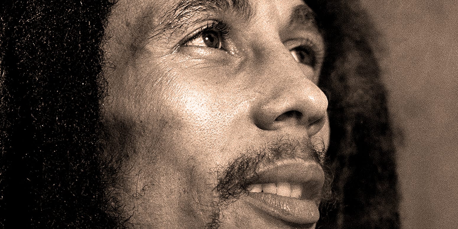 Close-up of a man with detailed facial features, including curly hair and a beard, reflecting historical and musical archives related to news, history, and music.