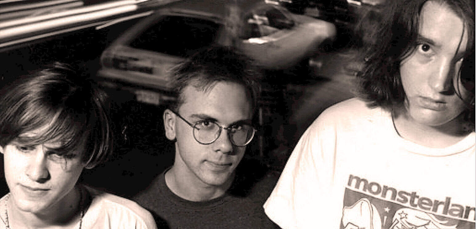 Vintage black and white photo of three young individuals with distinct hairstyles, capturing a nostalgic moment related to music, news, and history, reflecting the essence of Past Daily's sound archive.