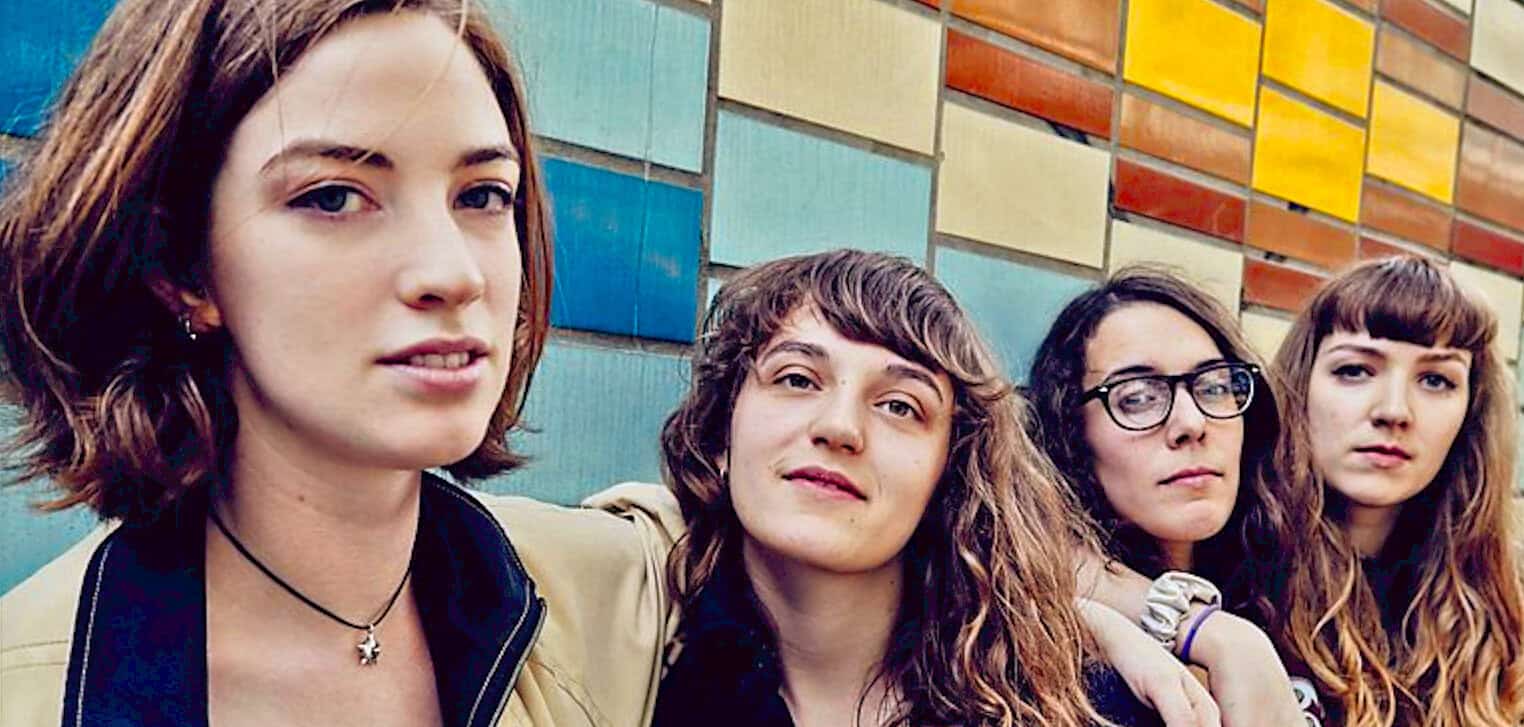 People of diverse backgrounds standing outdoors in front of colorful wall, friends and youth culture, casual fashion, togetherness and social connection, urban environment, contemporary lifestyle, modern photography.