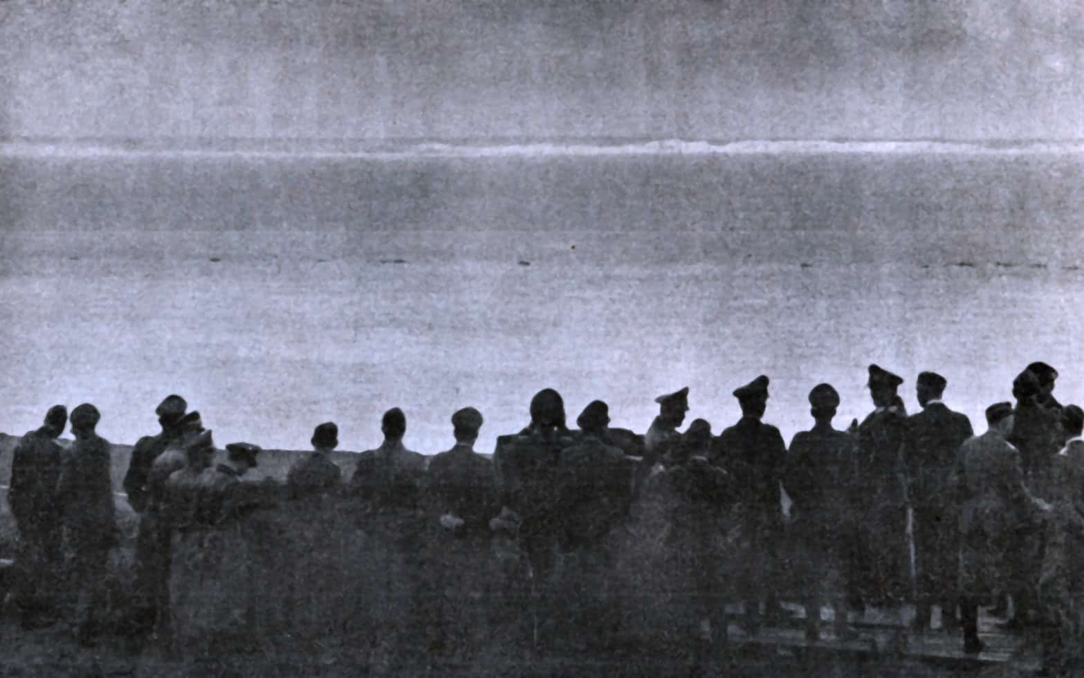 Aerial view of soldiers in uniform assembling outdoors, historic black-and-white photo capturing wartime military personnel, emphasizing history, news, and classic military imagery.