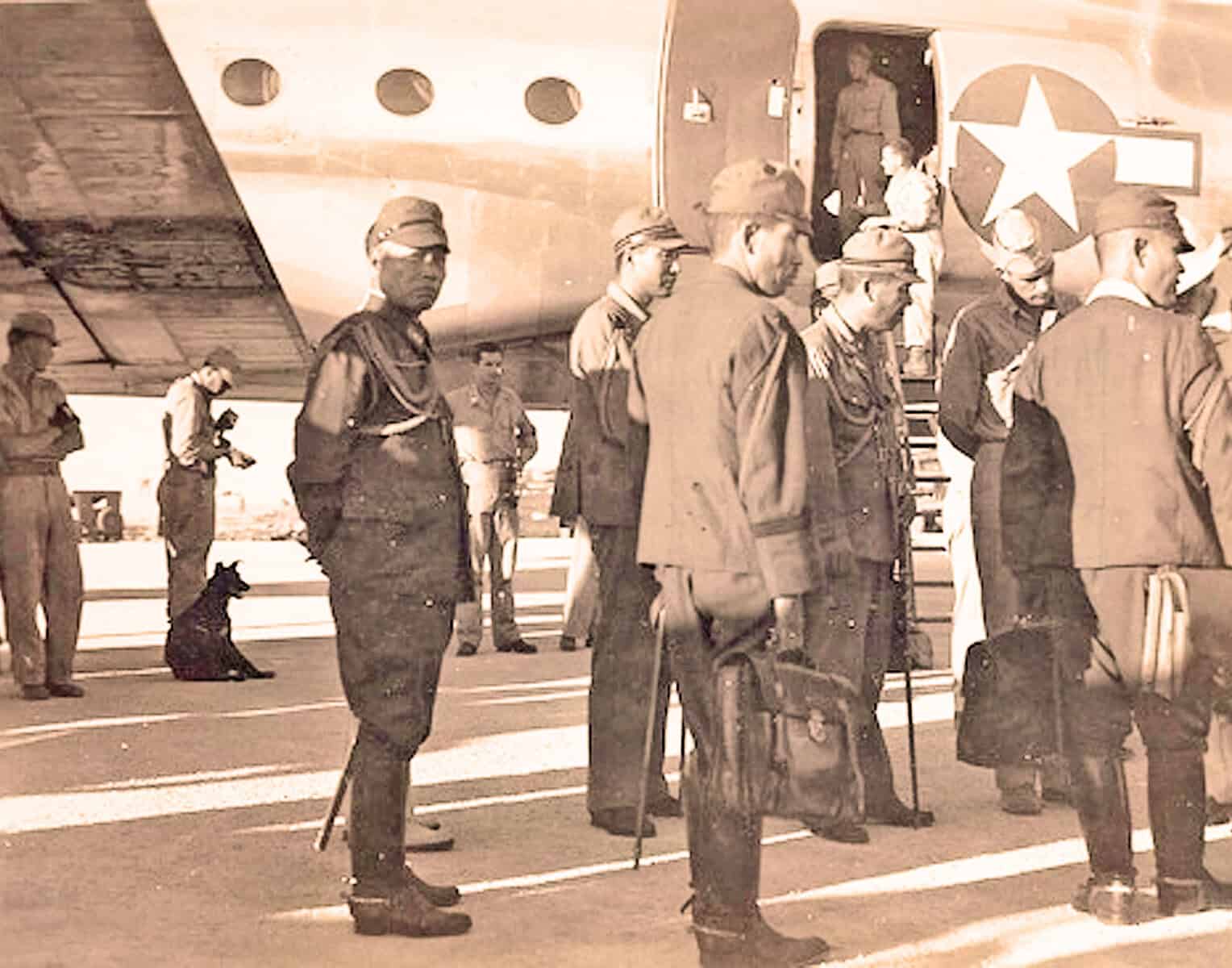 Vintage military personnel boarding a plane, historical black and white photo, World War II, military history, soldiers with luggage, aircraft background.