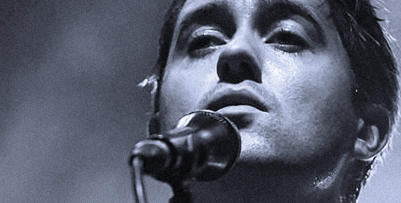 Close-up image of a female singer performing with a microphone, capturing emotion and intensity, highlighting the importance of music archives, news, and history documented by Past Daily.