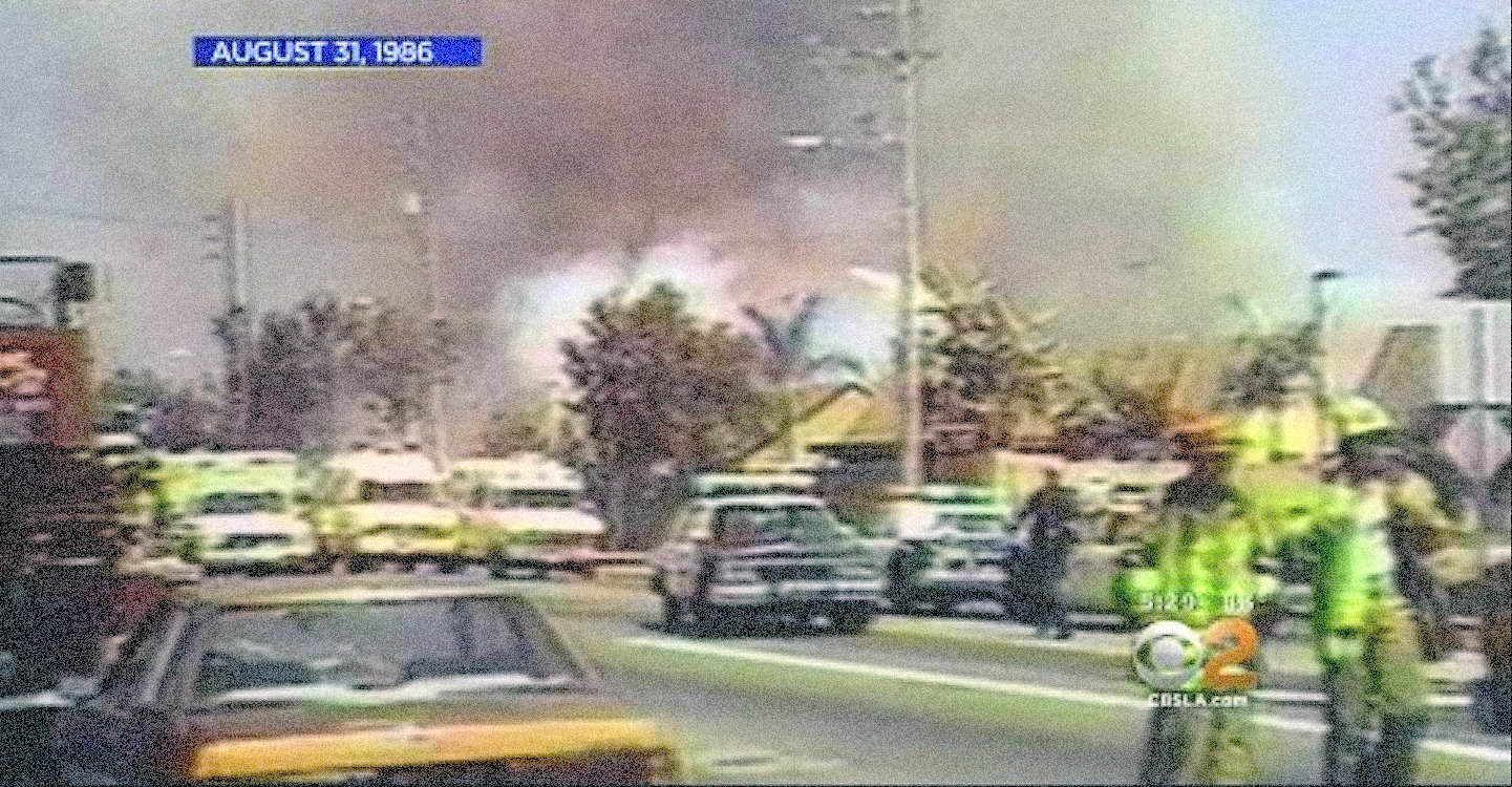 Burning vehicle fire with smoke and emergency responders on scene, August 31, 1986. Historic news footage capturing an urban accident and firefighting efforts from the 1980s.