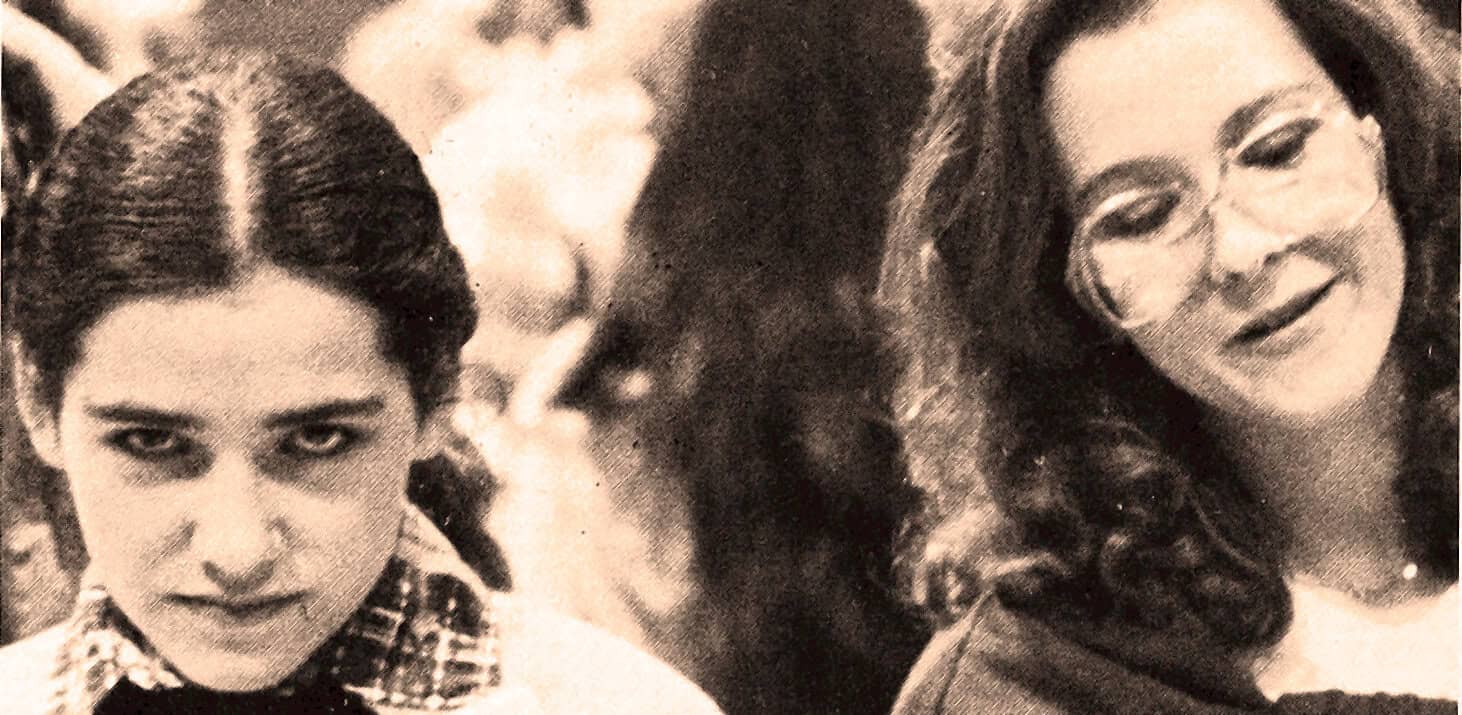 Young women engaged in a conversation showcasing vintage style and cultural history, related to news, music, and historic sound archives from Past Daily.