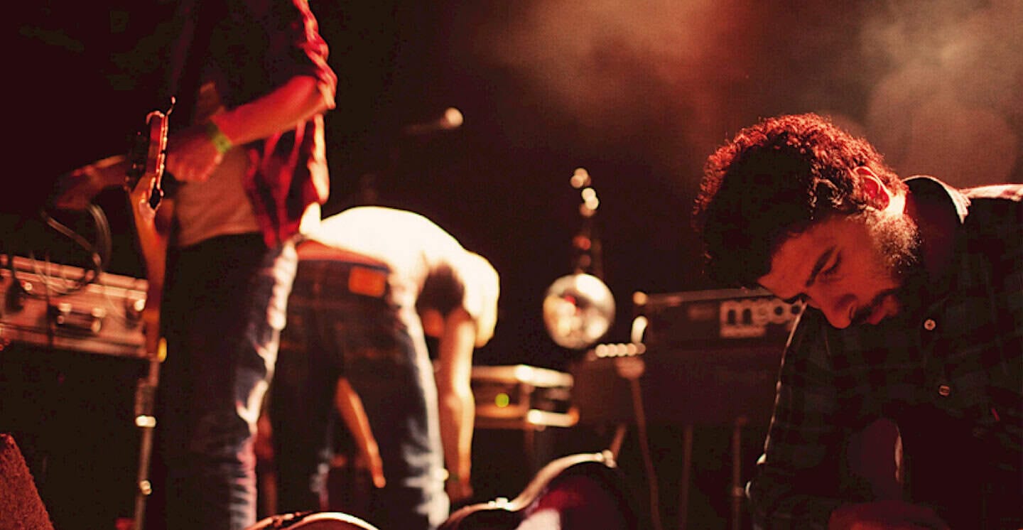 Vintage live music performance featuring musicians, sound equipment, and stage lighting, capturing a moment of musical history and sound archive documentation.