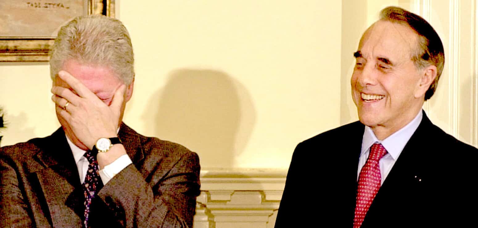 Laughing men in formal suits sharing a humorous moment, symbolizing news, history, and music archive from Past Daily.