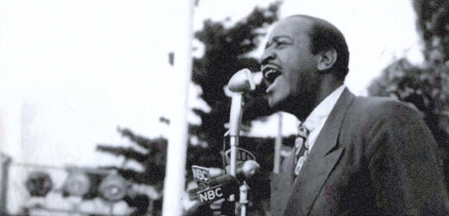 Man speaking passionately at a historic civil rights rally, vintage black and white photo, with microphones labeled NBC, illustrating history, news, and social justice moments captured by Past Daily.