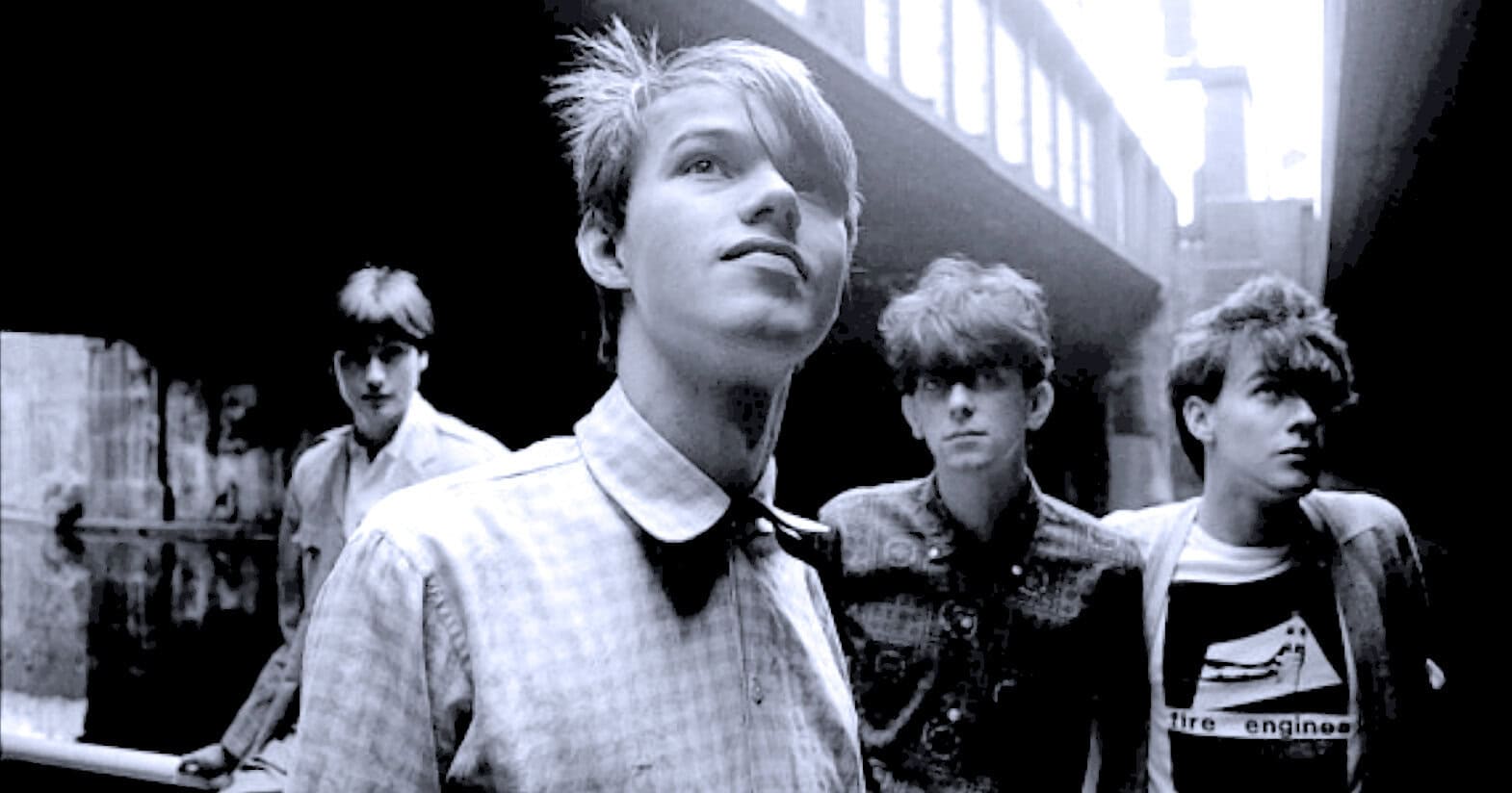 Hidden Cities: Black and White Photo of Indie Rock Band Members Walking in an Urban Alleyway, Emphasizing Music, News, and History Archive Content.