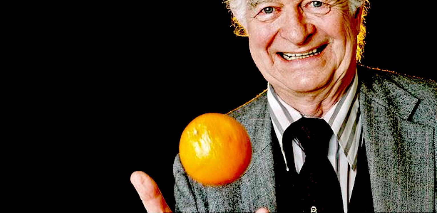 VINTAGE RADIO HOST HOLDING ORANGE ORAANGE IN HAND, MUSIC AND NEWS ARCHIVE, HISTORIC BROADCAST IMAGE, PAST DAILY SOUND ARCHIVE, NEWS, HISTORY, AND MUSIC CONTENT.