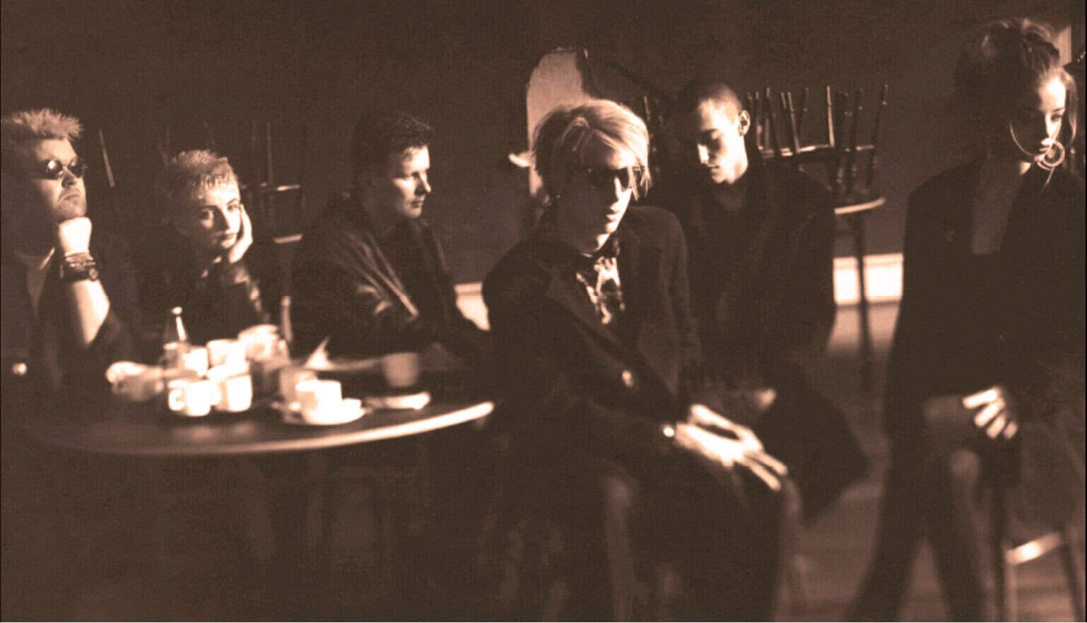 Vintage photo of five young people sitting at a table in a music or radio studio, capturing a nostalgic moment related to news, history, and music archives.
