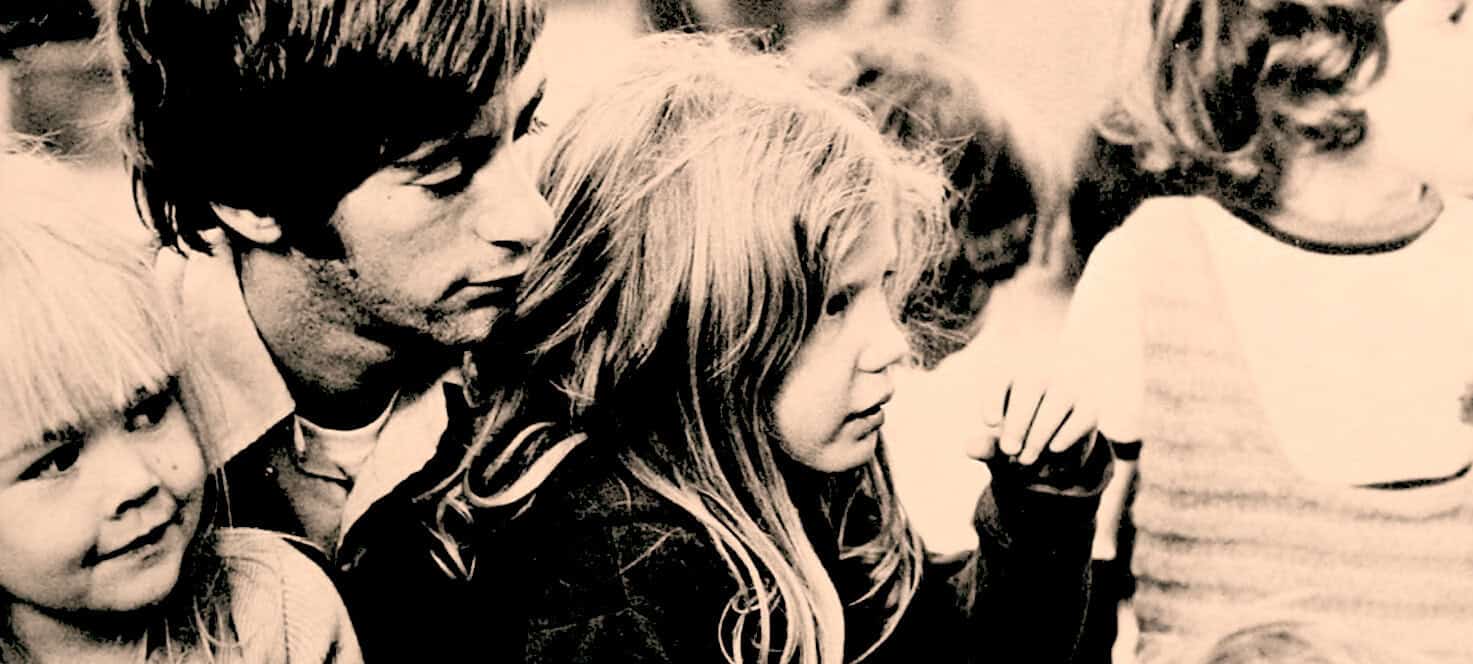 History of music and cultural moments captured in a vintage black and white photo, showcasing young people engaged in a group activity, representing the era's social and artistic expressions.